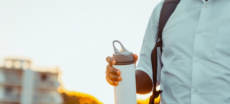 Person holding a thermos flask