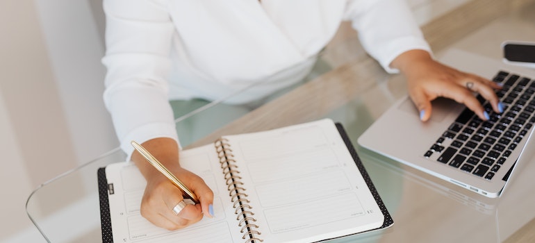 Woman using a pen to write in a notebook